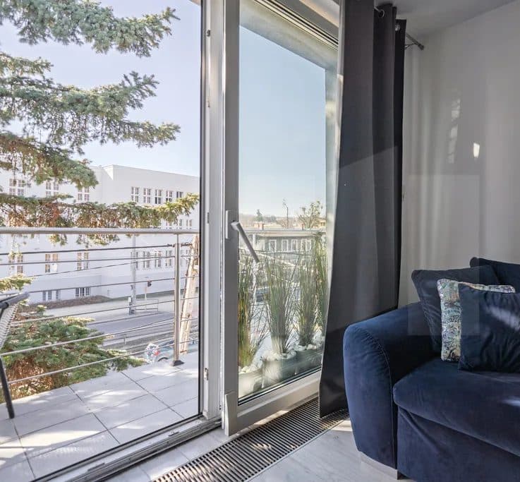 Salon z wyjściem na balkon w mieszkaniu w Orłowie